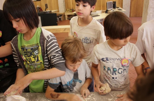ninos haciendo pan en un taller de verano